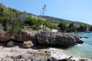 una playa con rocas y agua y una casa en Apartments by the sea Zavala, Hvar - 8809, en Jelsa 12 fotos más