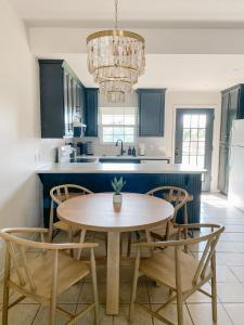 a kitchen with blue cabinets and a table and chairs at The Ruby - Modern Updated 4/2 Home Near ACU in Abilene
