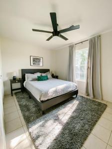 una camera con letto e ventilatore a soffitto di The Ruby - Modern Updated 4/2 Home Near ACU ad Abilene
