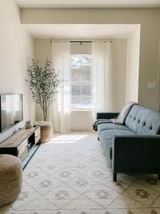 sala de estar con sofá azul y TV en The Ruby - Modern Updated 4/2 Home Near ACU en Abilene