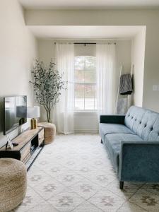 sala de estar con sofá azul y TV en The Ruby - Modern Updated 4/2 Home Near ACU, en Abilene