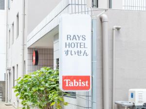 a sign for a tucks hotel twitch on the side of a building at Tabist Rays Hotel Suisen in Miyazaki