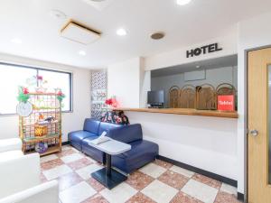 宮崎市にあるTabist Rays Hotel Suisenの青い椅子とテーブルが備わるホテルの待合室
