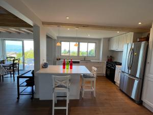 a kitchen with a kitchen island with chairs and a refrigerator at Maison Évian-les-Bains, 6 pièces, 7 personnes - FR-1-498-79 in Évian-les-Bains