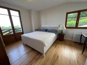 sypialnia z białym łóżkiem i drewnianą podłogą w obiekcie Maison Évian-les-Bains, 6 pièces, 7 personnes - FR-1-498-79 w mieście Évian-les-Bains