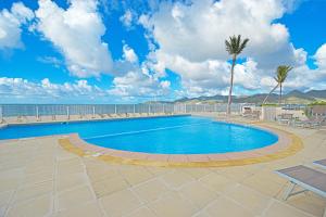 a swimming pool with a view of the ocean at Deja Blue - Comfortable Beachfront condo in Marigot