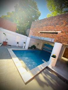 a swimming pool in front of a house at Hotel Hassler in Asuncion