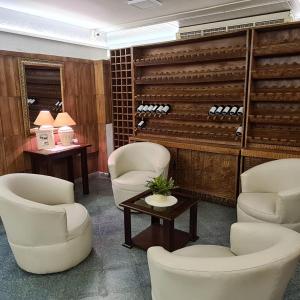 uma sala de espera com cadeiras brancas e garrafas de vinho em Hotel Hassler em Assunção