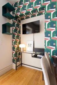 een woonkamer met een tv en een kleurrijke muur bij BOUTIQUE Rentals-Isabella Ribeira Apt great views in Porto