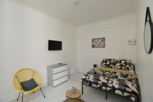 a bedroom with a bed and a tv and a chair at Home Group in Saint-Quentin