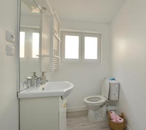 Baño blanco con lavabo y aseo en Home Group en Saint-Quentin