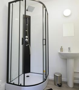 y baño con ducha de cristal y lavabo. en Home Group en Saint-Quentin