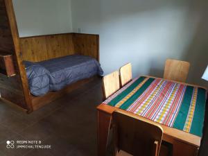 a bedroom with a bed and a table and chairs at LodeJimmy in El Chalten