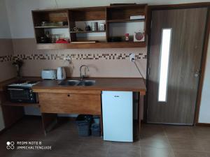 a kitchen with a sink and a counter with a refrigerator at LodeJimmy in El Chalten
