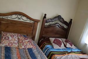 a bedroom with two beds and a wooden headboard at Depto comodo centrico cerca a colegios;hospitales in Cochabamba