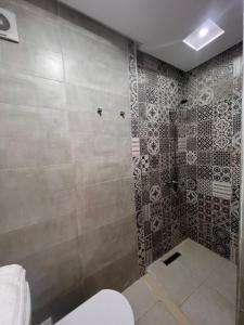 a bathroom with a shower with a tile wall at Martil beach in Martil +40 photos