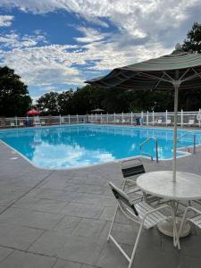 a swimming pool with a table and an umbrella at Penthouse suite at Holiday Hills Book today in Branson