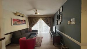 uma sala de estar com um sofá e uma televisão em Condo D'Savoy @ Famosa, Malacca em Malaca