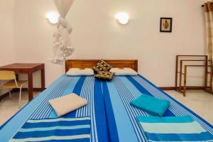 niebiesko-białe łóżko z dwoma poduszkami w obiekcie La Safari Inn Tissamaharama w mieście Tissamaharama