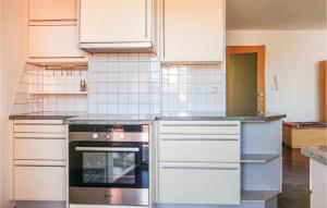 a kitchen with white cabinets and an oven at Stunning Apartment In Pinkafeld With 3 Bedrooms And Wifi in Neustift an der Lafnitz
