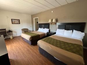 Cette chambre comprend deux lits et un bureau. dans l'établissement Posh Inn & Suites, à Wisconsin Rapids