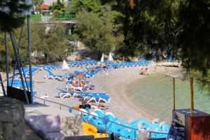 uma praia com cadeiras azuis e pessoas na água em Seaside house with a swimming pool Hvar - 12919 em Hvar