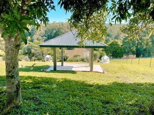 a gazebo in a park with a tree at Seven Peaks Farm Stay in Beerwah