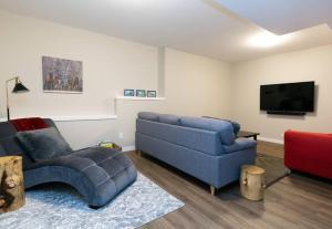 salon z niebieską kanapą i telewizorem w obiekcie North Shore Estates Getaway w mieście Lake Cowichan