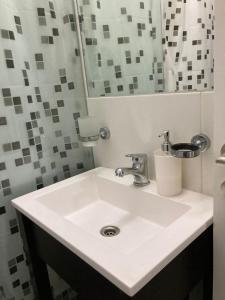 ein Badezimmer mit einem weißen Waschbecken und einem Spiegel in der Unterkunft Brasil flats-Nueva Cordoba in Cordoba