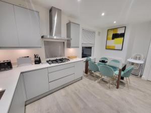a kitchen with a table and a dining room at Garland Modern 4 Bedroom Central Apartment London in Finchley