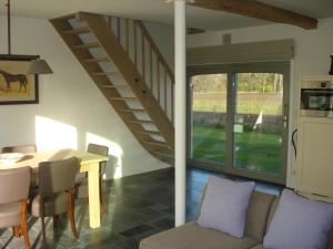 ein Wohnzimmer mit einem Tisch und einer Treppe in der Unterkunft Hoeve De Hagepoorter in Jabbeke