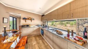 a kitchen with wooden cabinets and a large window at Tea Tree Hollow in Canyon Leigh