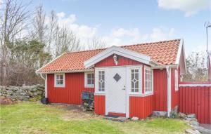 um barracão vermelho com uma porta branca e uma cerca em Gorgeous Home In sa With Wifi em Åsa
