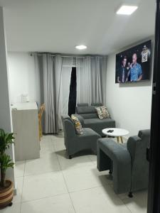 sala de estar con sofás y TV en la pared en Apartamento vacacional amoblado, en Armenia