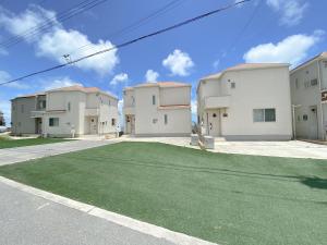 沖縄市にあるグランディオーソ沖縄ヴィラ金武1の緑の芝生の白い建物