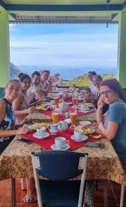 a group of people sitting at a long table at Hilltop Guest House in Ella