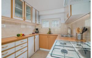 a kitchen with wooden cabinets and a stove top oven at 4 Bedroom Stunning Home In Omisalj in Omišalj