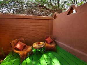 a patio with two chairs and a table and a fence at Hotel Pascual Andino in San Pedro de Atacama