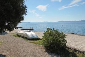 un bateau assis sur la rive d'une masse d'eau dans l'établissement Holiday house with a parking space Kozino, Zadar - 14464, à Petrčane