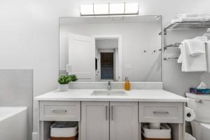 a white bathroom with a sink and a mirror at Beach Suites in Parksville