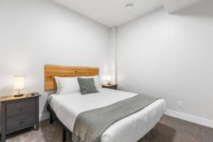 a bedroom with a bed and a nightstand with two lamps at Beach Suites in Parksville