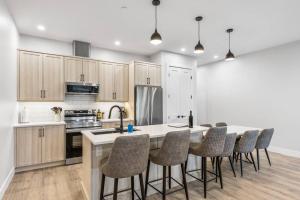 a kitchen with a large island with bar chairs at Beach Suites in Parksville