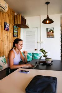 a woman sitting at a desk with a laptop computer at Tiki Beach Koh Phangan in Ban Tai