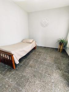 Un dormitorio con una cama y una planta. en Casa Barrio Sur COMODA en San Miguel de Tucumán