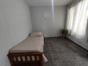 ein kleines Schlafzimmer mit einem Bett und einem Fenster in der Unterkunft Casa Barrio Sur COMODA in San Miguel de Tucumán