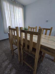 einen Holztisch und zwei Stühle neben einem Fenster in der Unterkunft Casa Barrio Sur COMODA in San Miguel de Tucumán