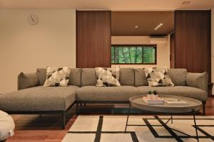 uma sala de estar com um sofá e uma mesa em Fandina藤原 em Azumaiokozan
