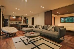 a living room with a couch and a table at Fandina藤原 in Azumaiokozan