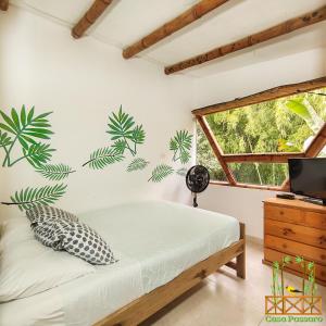 una camera da letto con un letto con una pianta sul muro di Casa Passaro a Calarcá