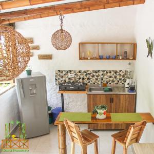 a kitchen with a refrigerator and a table with chairs at Casa Passaro in Calarcá +10 photos